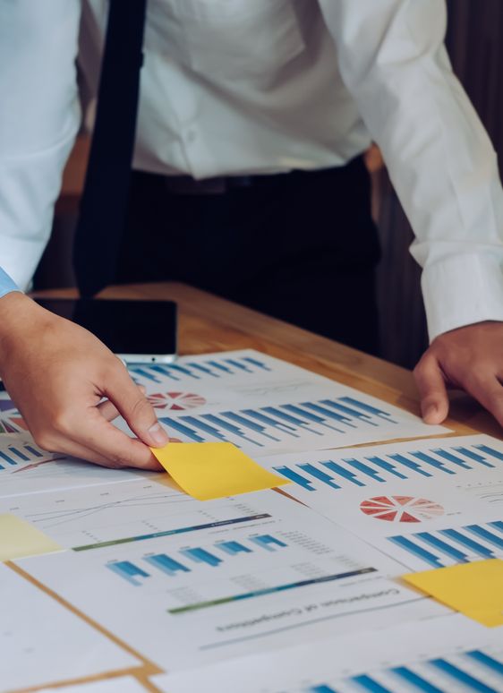 A pair of corporate workers annotate charts on a table